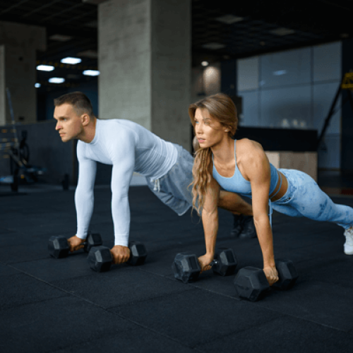 couple-doing-push-ups-with-dumbbells-in-gym